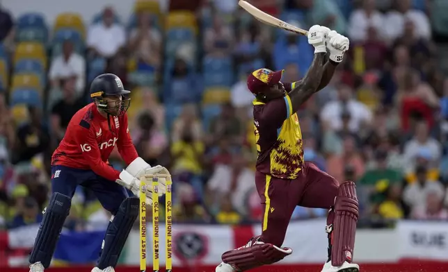 West Indies' captain captain Rovman Powell plays a shot for six runs as England's Phil Salt keeps wicket during the second T20 cricket match at Kensington Oval in Bridgetown, Barbados, Sunday, Nov. 10, 2024. (AP Photo/Ricardo Mazalan)