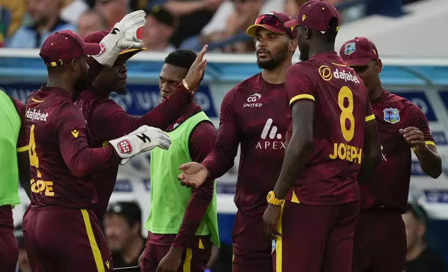 Teammates celebrate with West Indies' Brandon King, center, after he took the catch to dismiss England's Phil Salt during the third ODI cricket match at Kensington Oval in Bridgetown, Barbados, Wednesday, Nov. 6, 2024. (AP Photo/Ricardo Mazalan)