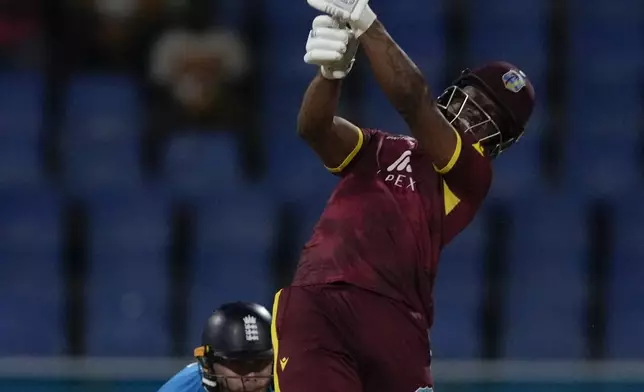 West Indies' Evin Lewis hits a six from a delivery of England's Adil Rashid during the first ODI cricket match at Sir Vivian Richards Ground in North Sound, Antigua and Barbuda, Thursday, Oct. 31, 2024. (AP Photo/Ricardo Mazalan)