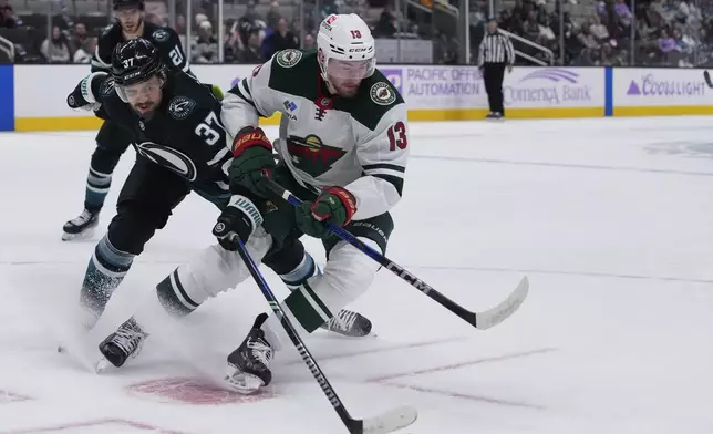 San Jose Sharks defenseman Timothy Liljegren (37) and Minnesota Wild center Yakov Trenin (13) compete for possession of the puck during the second period of an NHL hockey game Thursday, Nov. 7, 2024, in San Jose, Calif. (AP Photo/Godofredo A. Vásquez)