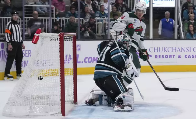 Minnesota Wild center Joel Eriksson Ek, right, watches as San Jose Sharks goaltender Vitek Vanecek is unable to stop a goal by left wing Matt Boldy during the second period of an NHL hockey game Thursday, Nov. 7, 2024, in San Jose, Calif. (AP Photo/Godofredo A. Vásquez)