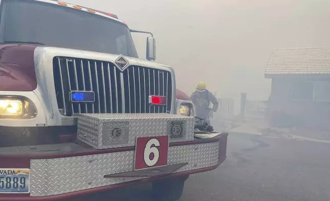 In this handout photo provided by the Reno Fire Department, fire crews battle the Callahan Fire, which caused the evacuations of hundreds of homes southwest of Reno, Nev., Monday, Nov. 11, 2024 (Reno Fire Department via AP)