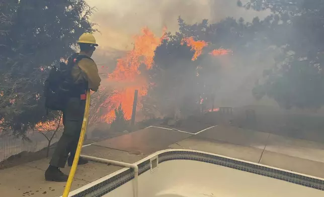 In this handout photo provided by the Reno Fire Department, fire crews battle the Callahan Fire, which caused the evacuations of hundreds of homes southwest of Reno, Nev., Monday, Nov. 11, 2024. (Reno Fire Department via AP)