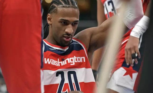 Teammates help Washington Wizards forward Alexandre Sarr (20) to his feet in the first half of an NBA basketball game against the Memphis Grizzlies Friday, Nov. 8, 2024, in Memphis, Tenn. (AP Photo/Brandon Dill)