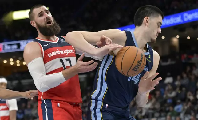 Memphis Grizzlies center Zach Edey (14) handles the ball against Washington Wizards center Jonas Valanciunas (17) in the first half of an NBA basketball game Friday, Nov. 8, 2024, in Memphis, Tenn. (AP Photo/Brandon Dill)