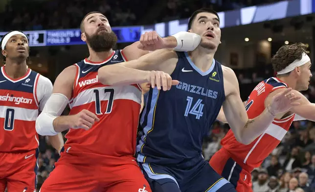 Washington Wizards center Jonas Valanciunas (17) and Memphis Grizzlies center Zach Edey (14) move for position in the first half of an NBA basketball game Friday, Nov. 8, 2024, in Memphis, Tenn. (AP Photo/Brandon Dill)
