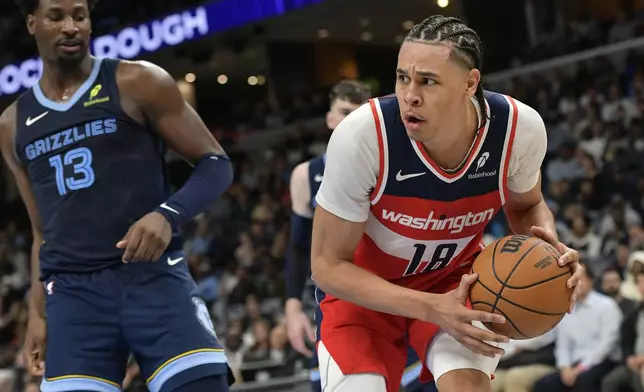 Washington Wizards forward Kyshawn George (18) handles the ball ahead of Memphis Grizzlies forward Jaren Jackson Jr. (13) in the first half of an NBA basketball game Friday, Nov. 8, 2024, in Memphis, Tenn. (AP Photo/Brandon Dill)