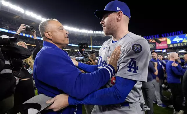 Los Angeles Dodgers manager Dave Roberts and Freddie Freeman celebrate their win against the New York Yankees in Game 5 to win the baseball World Series, Wednesday, Oct. 30, 2024, in New York. (AP Photo/Ashley Landis)