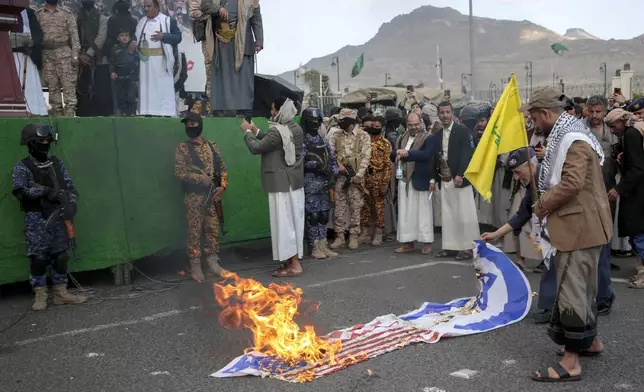 Houthi supporters burn American and Israeli flags during an Anti- U.S and Israel rally in Sanaa, Yemen, Friday, Nov. 8, 2024. (AP Photo/Osamah Abdulrahman)