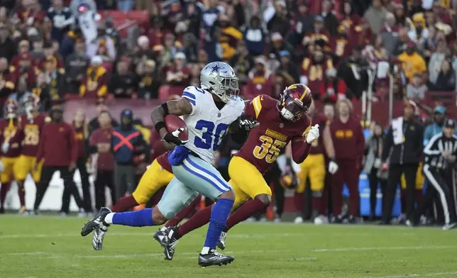 Dallas Cowboys safety Juanyeh Thomas (30) celebrates after scoring a 43-yard touchdown off a kickoff return during the second half of an NFL football game against the Washington Commanders, Sunday, Nov. 24, 2024, in Landover, Md. (AP Photo/Stephanie Scarbrough)