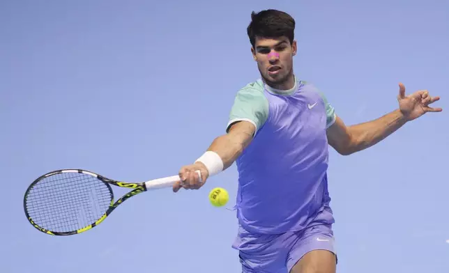 Spain's Carlos Alcaraz returns the ball to Germany's Alexander Zverev during their singles tennis match of the ATP World Tour Finals at the Inalpi Arena, in Turin, Italy, Friday, Nov. 15, 2024. (AP Photo/Antonio Calanni)