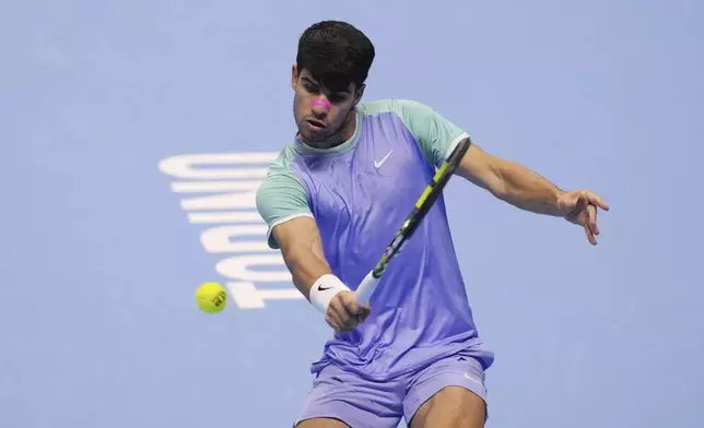 Spain's Carlos Alcaraz returns the ball to Germany's Alexander Zverev during their singles tennis match of the ATP World Tour Finals at the Inalpi Arena, in Turin, Italy, Friday, Nov. 15, 2024. (AP Photo/Antonio Calanni)