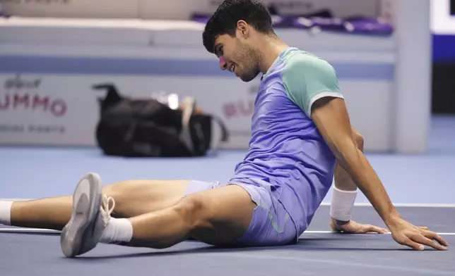 Spain's Carlos Alcaraz lies on the pitch during the singles tennis match of the ATP World Tour Finals against Germany's Alexander Zverev, at the Inalpi Arena, in Turin, Italy, Friday, Nov. 15, 2024. (AP Photo/Antonio Calanni)