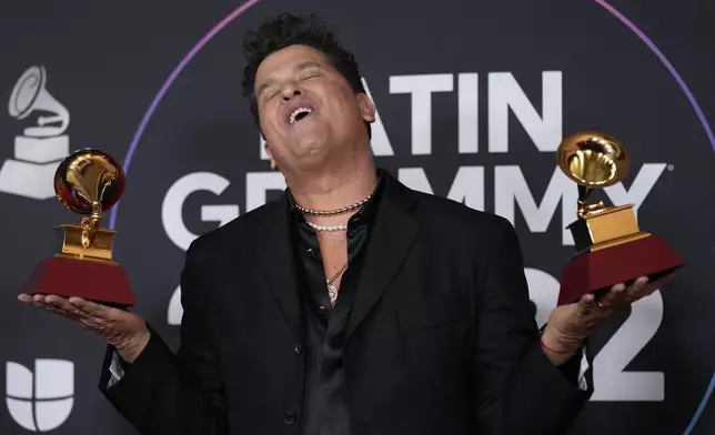 FILE - Carlos Vives poses in the press room with his Latin Grammy gramophone-shaped trophies awarded for best pop/rock and best contemporary tropical album, at the 23rd Annual Latin Grammy Awards in Las Vegas, Nov. 17, 2022. (AP Photo/John Locher, File)