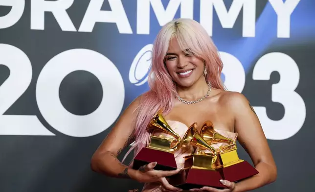 FILE - Karol G poses with her Latin Grammy gramophone-shaped trophies for best urban album; album of the year; and best urban fusion/performance, during the 24th Annual Latin Grammy Awards ceremony, in Seville, Spain, Nov. 16, 2023. (Photo by Jose Breton/Invision/AP File)