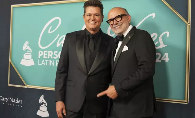 Carlos Vives, the Latin Grammys Person of the Year, poses with CEO Manuel Abud, Wednesday, Nov. 13, 2024, in Miami Beach, Fla. (AP Photo/Lynne Sladky)