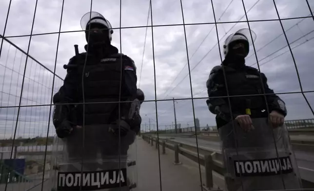 Serbian police officers guard Old Sava Bridge, which is closed for removal, in Belgrade, Serbia, Wednesday, Nov. 20, 2024. (AP Photo/Darko Vojinovic)