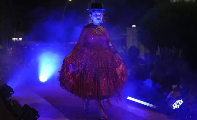 A woman models a creation by a local designer at a Chola fashion show, promoting the Andean style and beauty of Aymara women, in Viacha, Bolivia, Friday, Nov. 29, 2024. (AP Photo/Juan Karita)