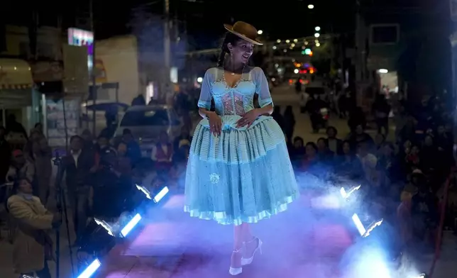 A woman models a creation by a local designer at a Chola fashion show, promoting the Andean style and beauty of Aymara women, in Viacha, Bolivia, Friday, Nov. 29, 2024. (AP Photo/Juan Karita)