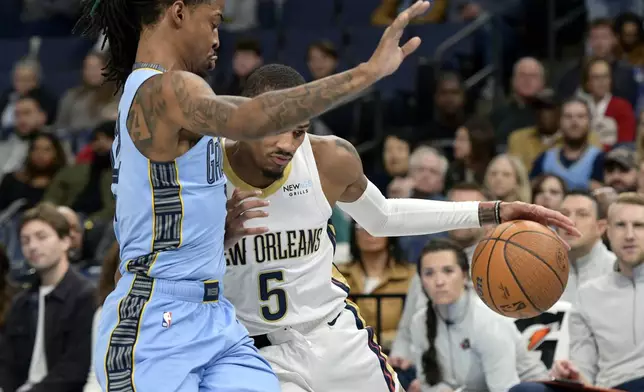 New Orleans Pelicans guard Dejounte Murray (5) handles the ball against Memphis Grizzlies guard Ja Morant (12) in the first half of an Emirates NBA Cup basketball game Friday, Nov. 29, 2024, in Memphis, Tenn. (AP Photo/Brandon Dill)