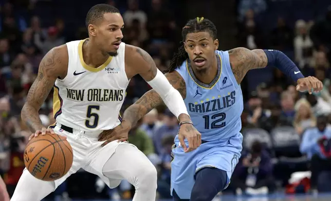 New Orleans Pelicans guard Dejounte Murray (5) handles the ball against Memphis Grizzlies guard Ja Morant (12) in the first half of an Emirates NBA Cup basketball game Friday, Nov. 29, 2024, in Memphis, Tenn. (AP Photo/Brandon Dill)