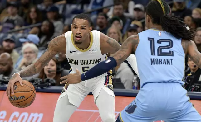 New Orleans Pelicans guard Dejounte Murray (5) handles the ball against Memphis Grizzlies guard Ja Morant (12) in the first half of an Emirates NBA Cup basketball game Friday, Nov. 29, 2024, in Memphis, Tenn. (AP Photo/Brandon Dill)