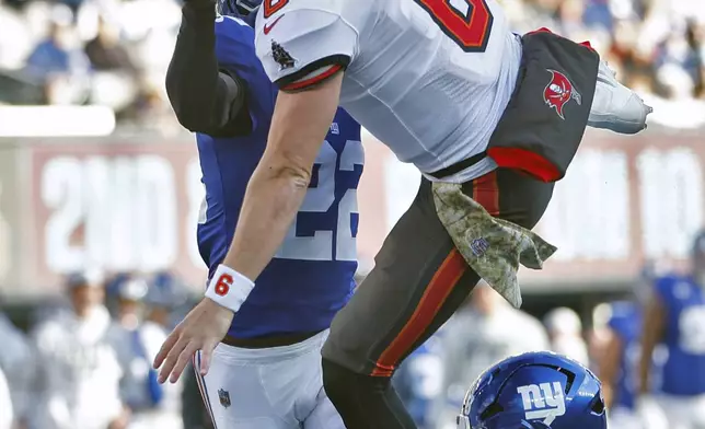 Tampa Bay Buccaneers quarterback Baker Mayfield (6) eludes New York Giants cornerback Dru Phillips (22) and cornerback Cor'Dale Flott (28) to score during the first half of an NFL football game Sunday, Nov. 24, 2024, in East Rutherford, N.J. (AP Photo/Rich Schultz)