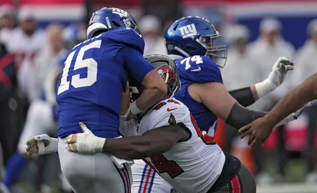 New York Giants quarterback Tommy DeVito (15) gets sacked by Tampa Bay Buccaneers defensive tackle Calijah Kancey (94) during the first half of an NFL football game Sunday, Nov. 24, 2024, in East Rutherford, N.J. (AP Photo/Seth Wenig)