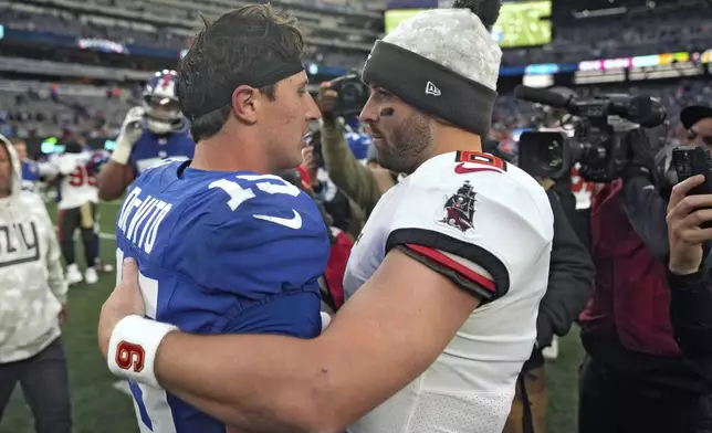 Tampa Bay Buccaneers quarterback Baker Mayfield and New York Giants quarterback Tommy DeVito (15) meet after an NFL football game Sunday, Nov. 24, 2024, in East Rutherford, N.J. (AP Photo/Seth Wenig)