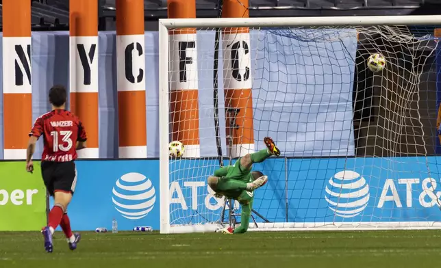 New York City FC goalkeeper Matthew Freese fails to stop a goal by New York Red Bulls midfielder Felipe Carballo, not shown, as Red Bulls' Dante Vanzeir (13) looks on during the first half of an MLS Cup semifinal soccer match, Saturday, Nov. 23, 2024, in New York. (AP Photo/Eduardo Munoz Alvarez)