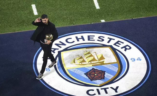 Manchester City's Rodri waves to fans with his Ballon d'Or Golden Ball trophy ahead of the British Premier League soccer match between Manchester City and Tottenham Hotspur, at the Etihad Stadium, Manchester, England, Saturday Nov. 23, 2024. (Carl Recine, Pool Photo via AP)