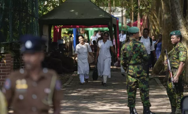 Workers leave a poll counting center following the parliamentary election in Colombo, Sri Lanka, Friday, Nov. 15, 2024. (AP Photo/Eranga Jayawardena)