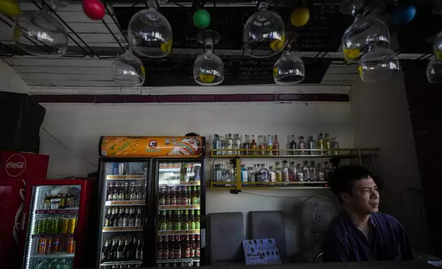 Duong Duc Toan, the manager of Nana Backpack hostel sits in the bar of the hostel in Vang Vieng, Laos, Tuesday, Nov. 19, 2024. (AP Photo/Anupam Nath)