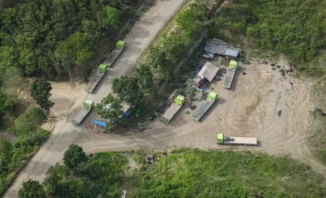 Trucks are parked near a road leading to areas of wood pellet production companies in Pohuwato, Gorontalo province, Indonesia, Tuesday, Oct. 22, 2024. (AP Photo/Yegar Sahaduta Mangiri)