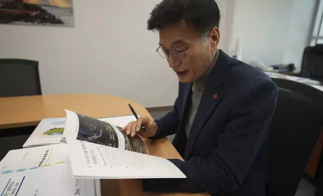 South Korean National Assembly member Moon Dae-Lim looks at a policy report on the state audit authored by him at his office of the National Assembly in Seoul, South Korea, Wednesday, Nov. 27, 2024. (AP Photo/Lee Jin-man)