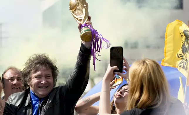 FILE - Presidential hopeful Javier Milei holds up a replica of the World Cup soccer trophy during a campaign rally in Lomas de Zamora, Argentina, Oct. 16, 2023. (AP Photo/Natacha Pisarenko, File)