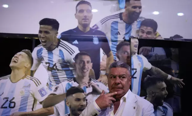 FILE - Claudio Tapia, president of the Argentina Soccer Association or AFA, backdropped by a bus banner of featuring World Cup 2022 team players, attends the "World Champions" exhibit in Buenos Aires, Argentina, April 5, 2023. (AP Photo/Natacha Pisarenko, File)