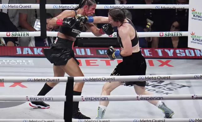 Katie Taylor, right, lands a right to Amanda Serrano during their undisputed super lightweight title bout, Friday, Nov. 15, 2024, in Arlington, Texas. (AP Photo/Julio Cortez)