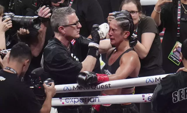 Amanda Serrano is attended to after fighting Katie Taylor in an undisputed super lightweight title bout, Friday, Nov. 15, 2024, in Arlington, Texas. (AP Photo/Julio Cortez)