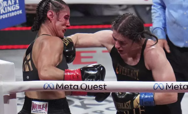 Katie Taylor, right, hits Amanda Serrano during their undisputed super lightweight title bout, Friday, Nov. 15, 2024, in Arlington, Texas. (AP Photo/Julio Cortez)