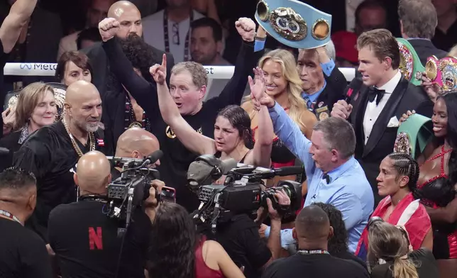 Katie Taylor, center, celebrates after defeating Amanda Serrano during their undisputed super lightweight title bout, Friday, Nov. 15, 2024, in Arlington, Texas. (AP Photo/Julio Cortez)