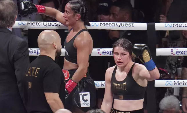 Amanda Serrano, left, and Katie Taylor react after their undisputed super lightweight title bout, Friday, Nov. 15, 2024, in Arlington, Texas. (AP Photo/Julio Cortez)