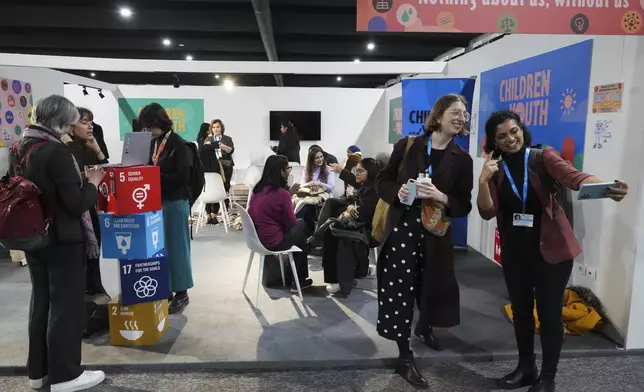 Attendees pose at the Children and Youth Pavilion at the COP29 U.N. Climate Summit, Monday, Nov. 18, 2024, in Baku, Azerbaijan. (AP Photo/Sergei Grits)