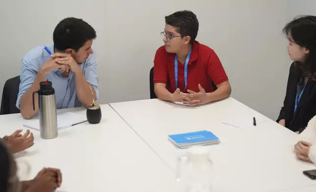 Francisco Vera Manzanares, 15, center, a climate activist from Colombia, speaks with Felipe Paullier, left, U.N. assistant secretary-general for youth affairs, during a forum with young activists, Tuesday, Nov. 12, 2024, at the COP29 U.N. Climate Summit in Baku, Azerbaijan. (AP Photo/Joshua A. Bickel)