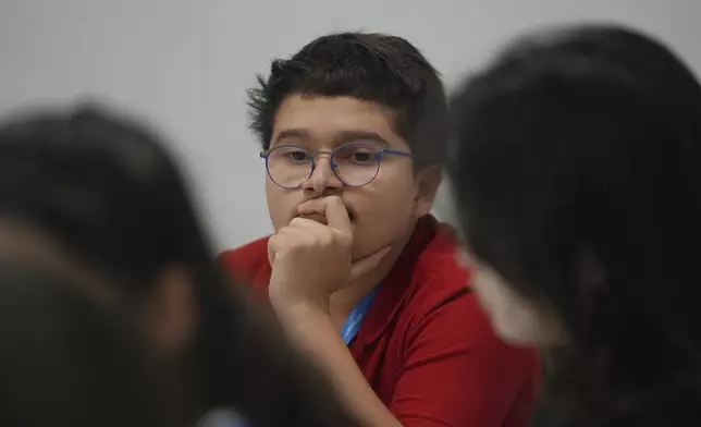 Francisco Vera Manzanares, 15, center, a climate activist from Colombia, listens during a forum with young activists, Tuesday, Nov. 12, 2024, at the COP29 U.N. Climate Summit in Baku, Azerbaijan. (AP Photo/Joshua A. Bickel)