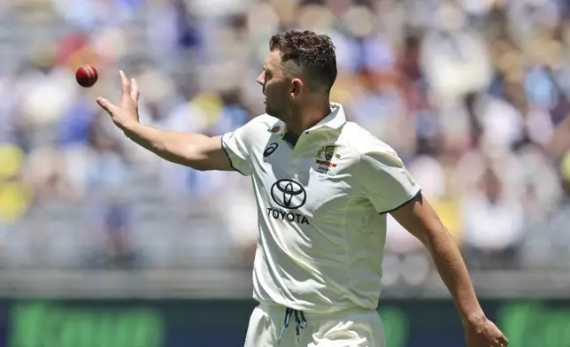 Australia's Josh Hazlewood collects the ball as he prepares to bowl during play in the first cricket test between India and Australia in Perth, Australia, Friday, Nov. 22, 2024. (AP Photo/Trevor Collens)