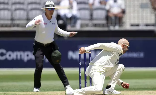 Australia's Nathan Lyon fields the ball during play in the first cricket test between India and Australia in Perth, Australia, Friday, Nov. 22, 2024. (AP Photo/Trevor Collens)