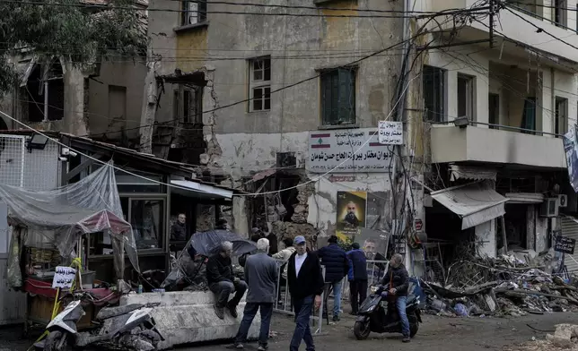 People stand next to a destroyed building hit on Monday evening by an Israeli airstrike in central Beirut, Lebanon, Tuesday, Nov. 19, 2024. (AP Photo/Bilal Hussein)