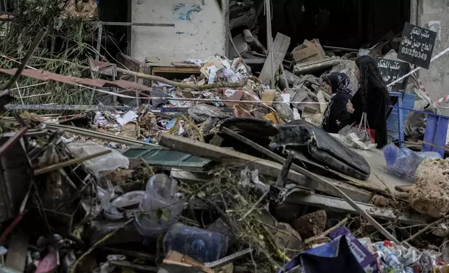 Women react as they pass through debris of a building hit on Monday evening by an Israeli airstrike in central Beirut, Lebanon, Tuesday, Nov. 19, 2024. (AP Photo/Bilal Hussein)