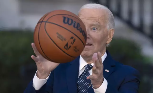 President Joe Biden throws a basketball he received from the Boston Celtics at an event to celebrate the team's victory in the 2024 National Basketball Association Championship, on the South Lawn of the White House in Washington, Thursday, Nov. 21, 2024. (AP Photo/Ben Curtis)